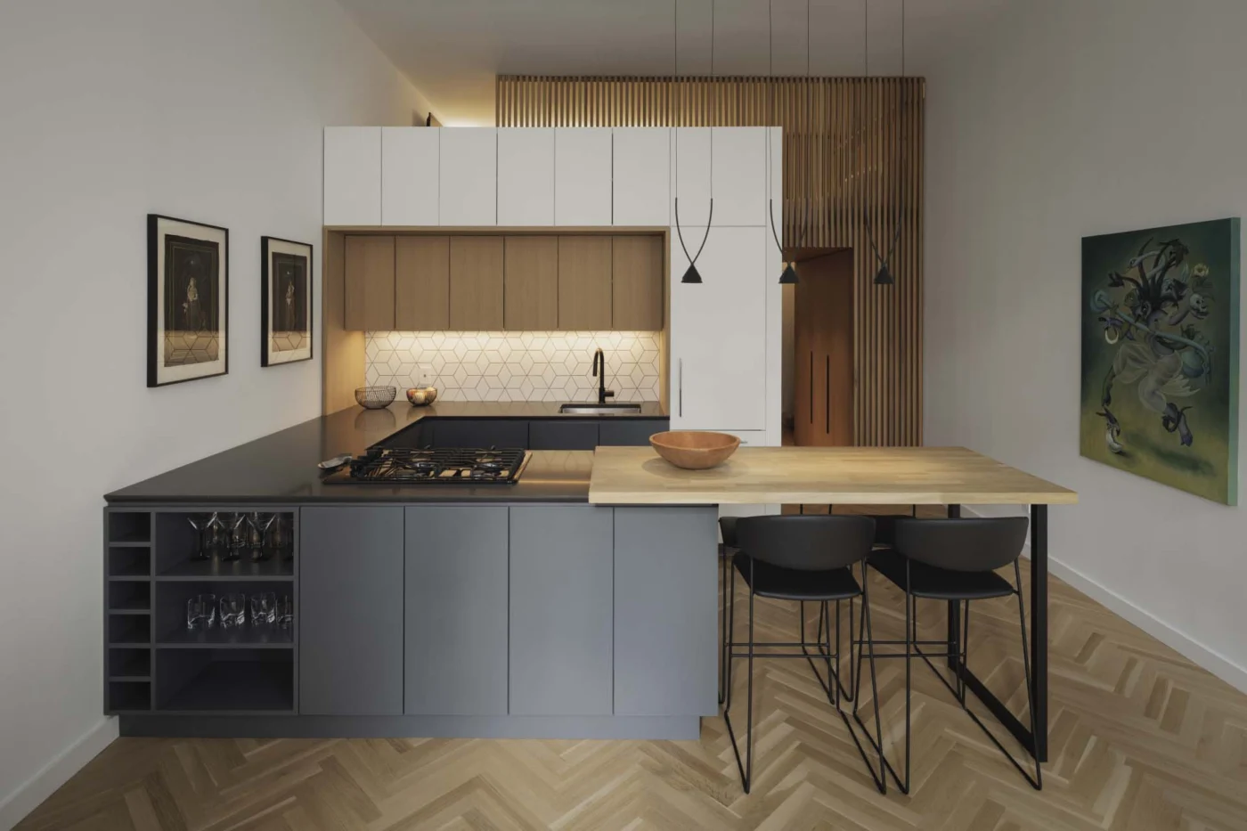 Kitchen island with dark grey and wood cabinets and black stools