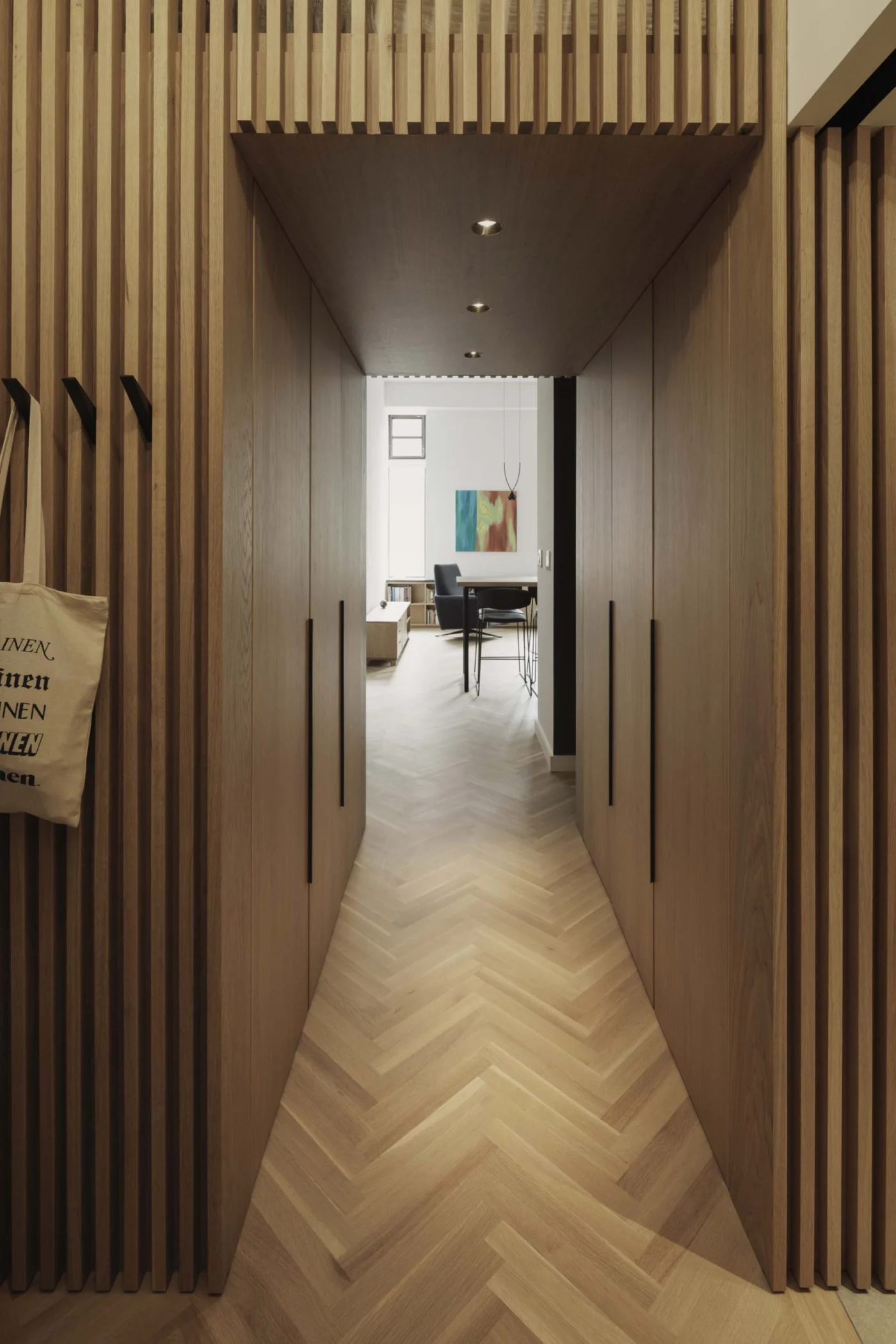 Entry hallway with white oak slat walls and hidden storage
