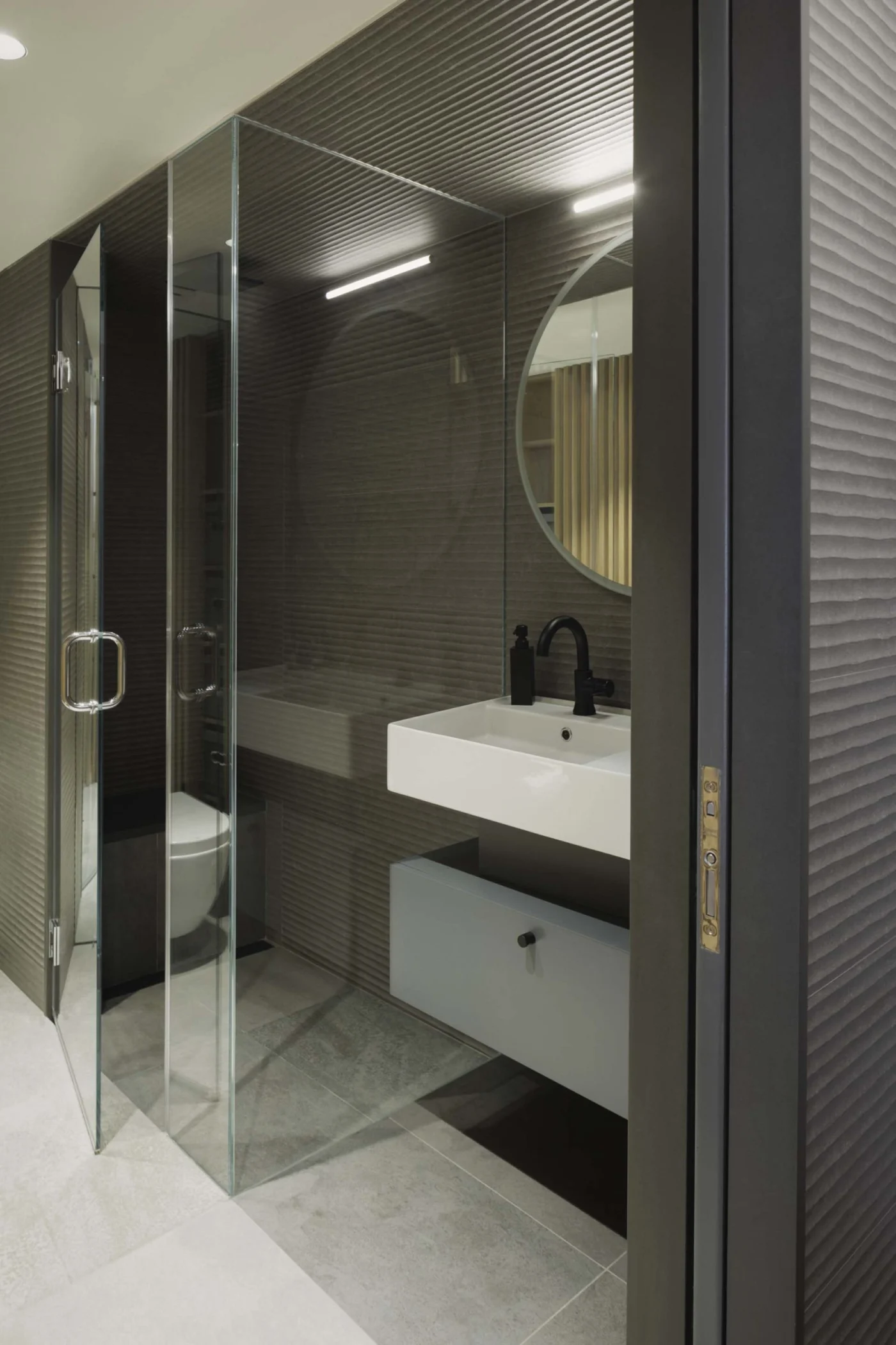 Bathroom in slate grey with a glass shower and floating vanity