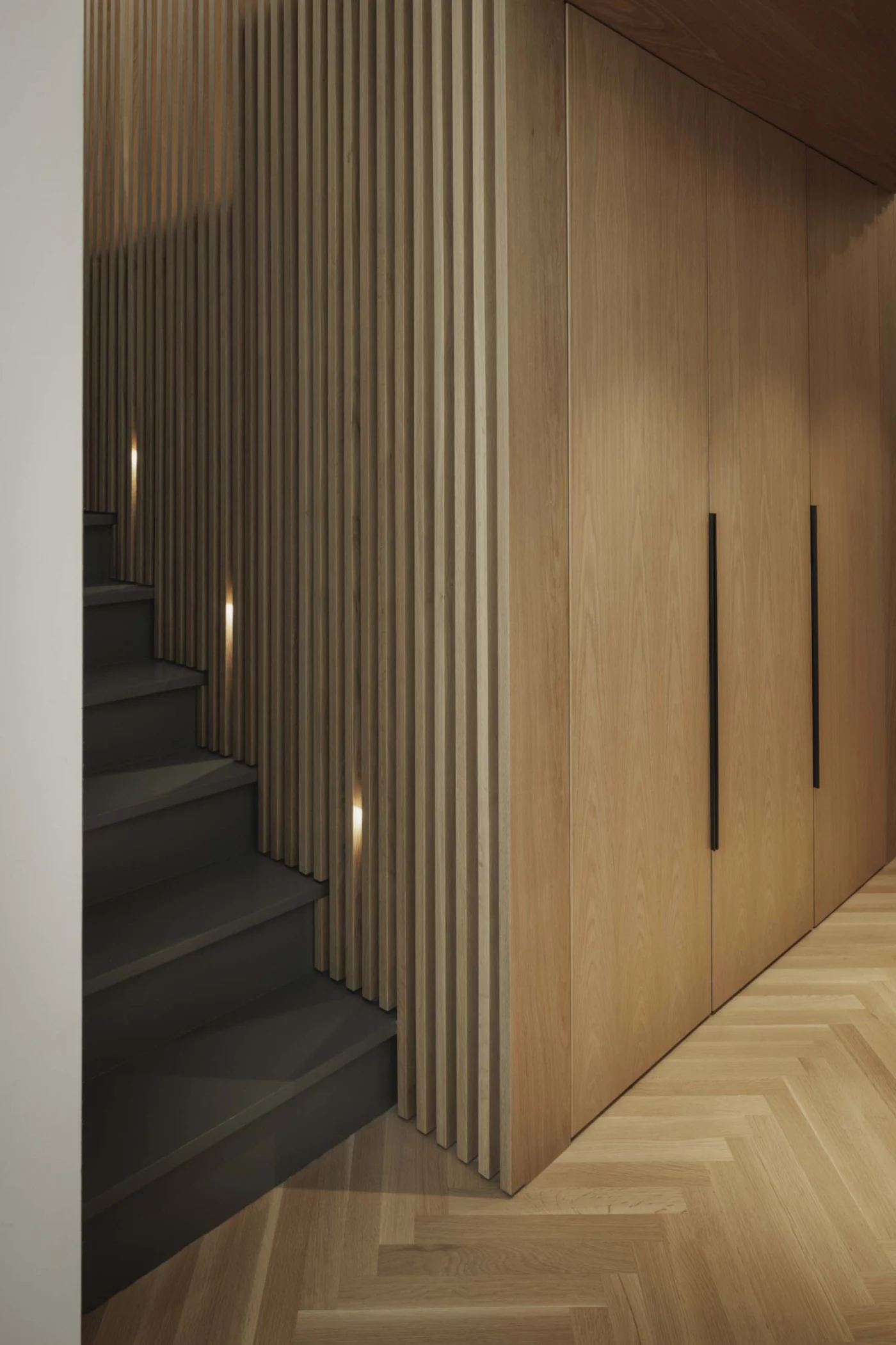 Stairs to the sleeping loft with lighting hidden in the wood slats