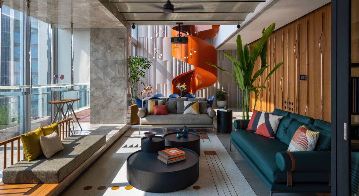 an-orange-spiral-staircase-is-an-eye-catching-feature-inside-this-apartment