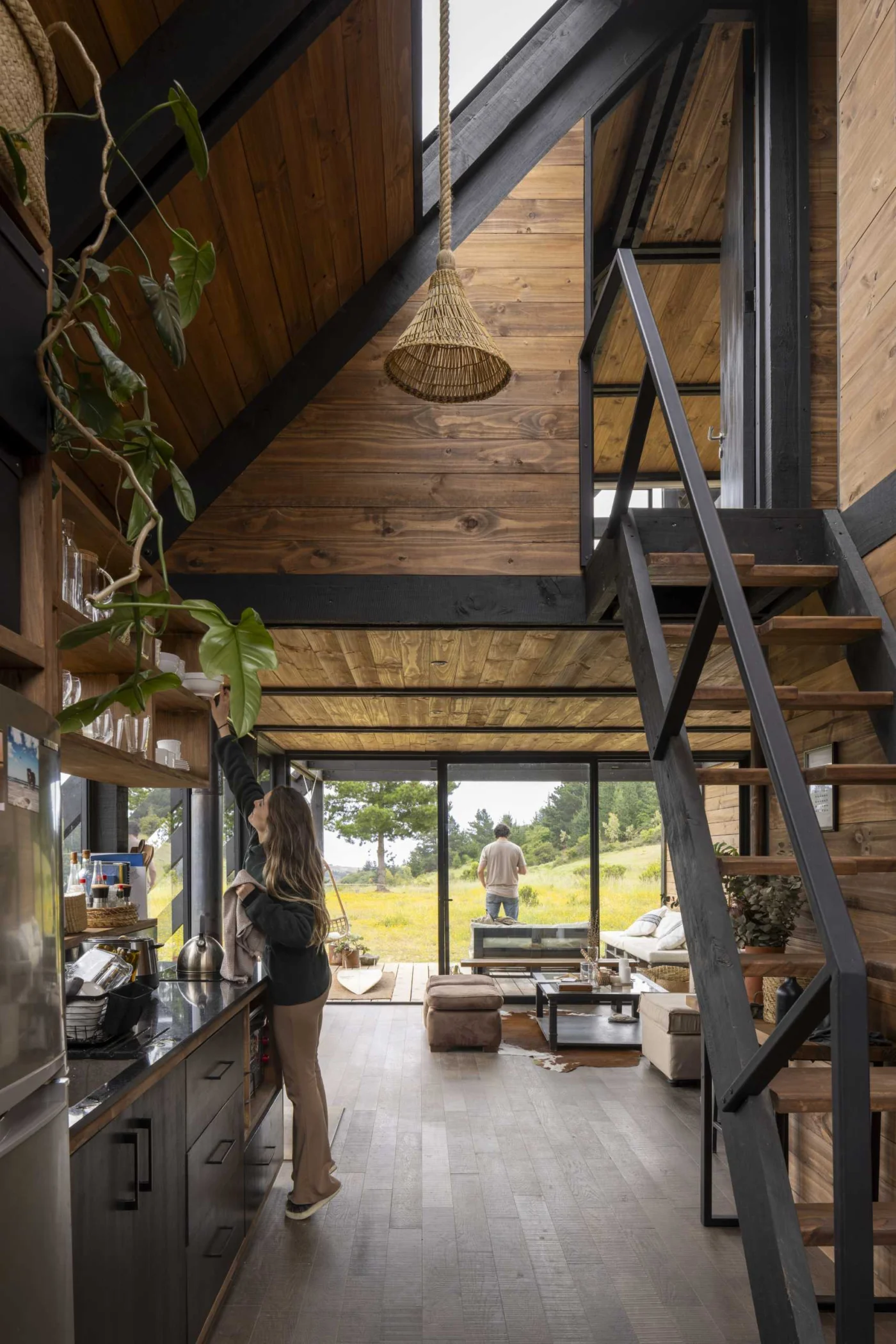 Kitchen next to the living room with stairs and a skylight above