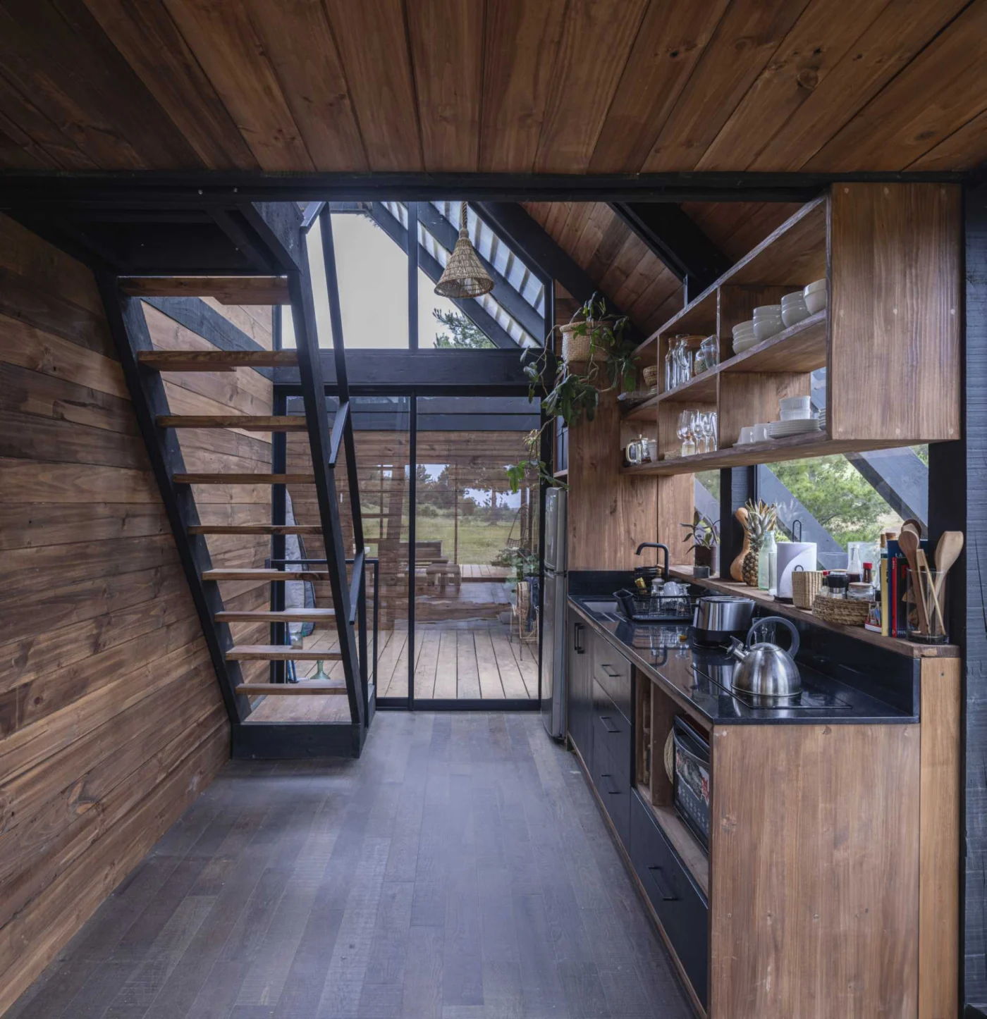 Narrow kitchen with open shelves and stairs leading up