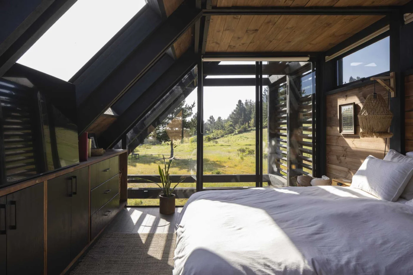 Bedroom under the sloping roof with a skylight and wide views