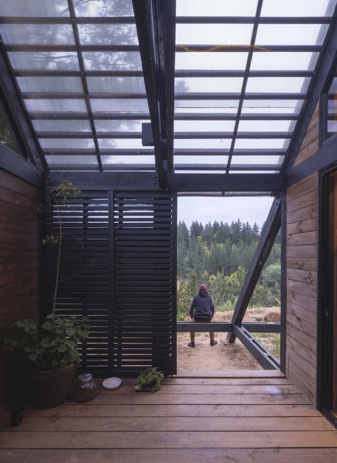 Covered deck with a sliding slatted door and glass roof