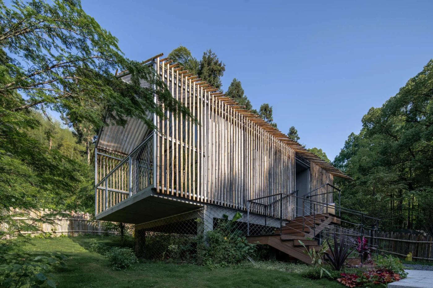 Bamboo hut at the forest edge wrapped in woven bamboo screens