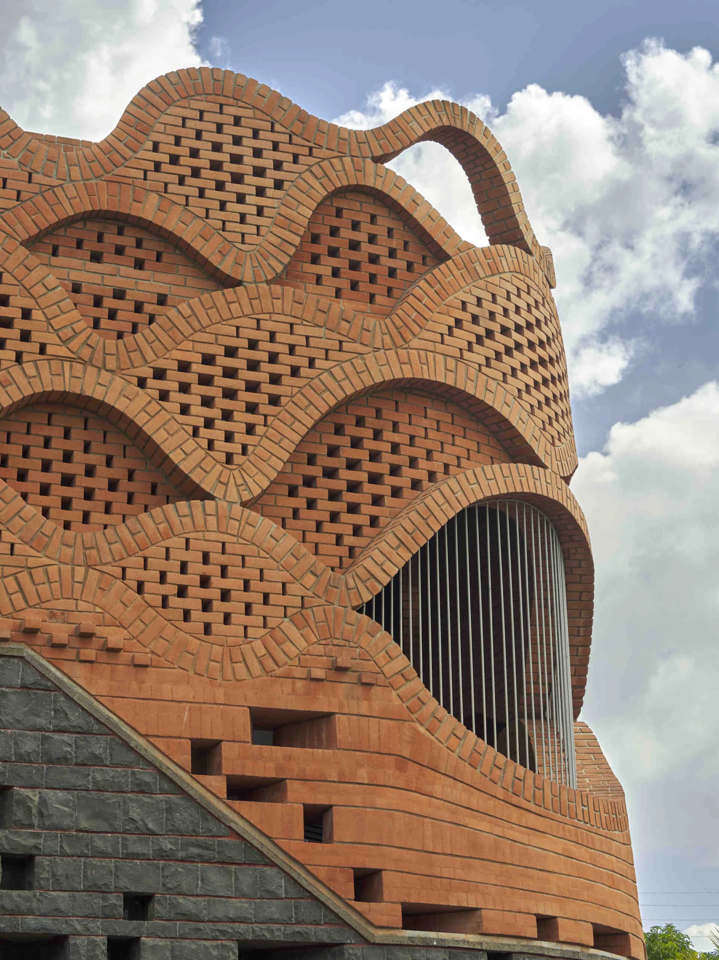 Curved brick openings layered like waves at the top of the house