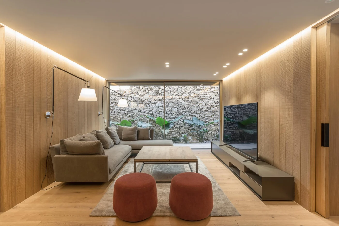 Wood-lined secondary living room with a window onto a stone wall