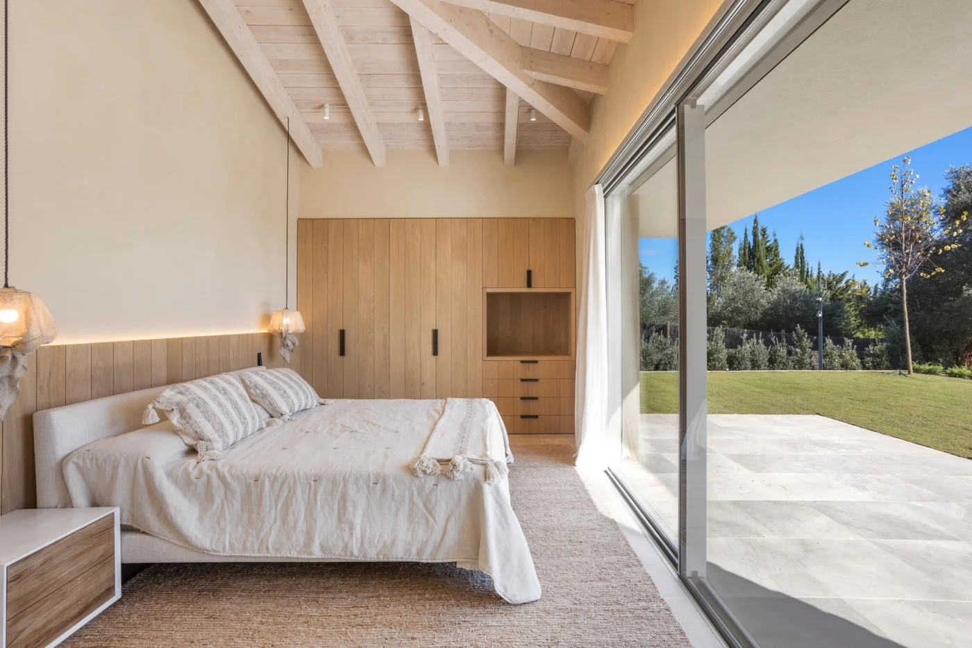 Bedroom with wood cabinetry and a sliding glass door to the garden